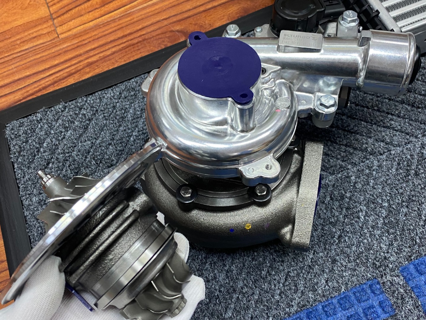 turbocharger assembly with detailed internal parts and gloved ha
