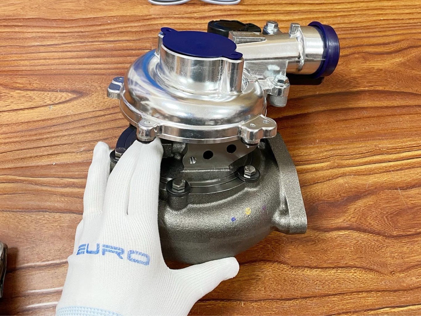 turbocharger assembly on wooden surface, highlighting turbine co