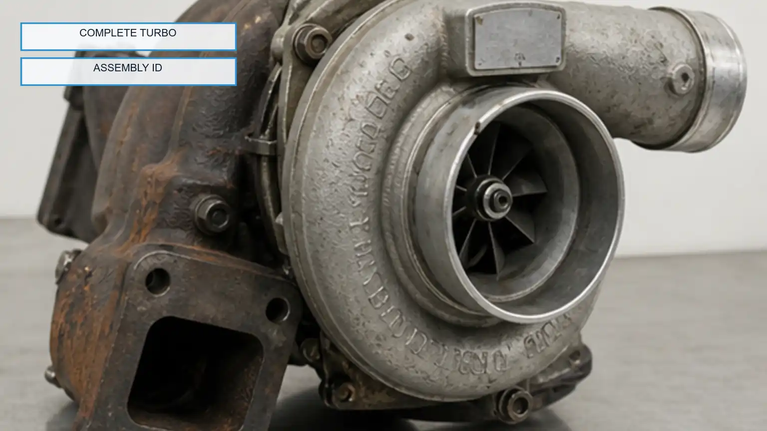 Removed heavy-duty turbocharger photographed as a complete assembly with compressor housing, turbine housing, and identification area visible.