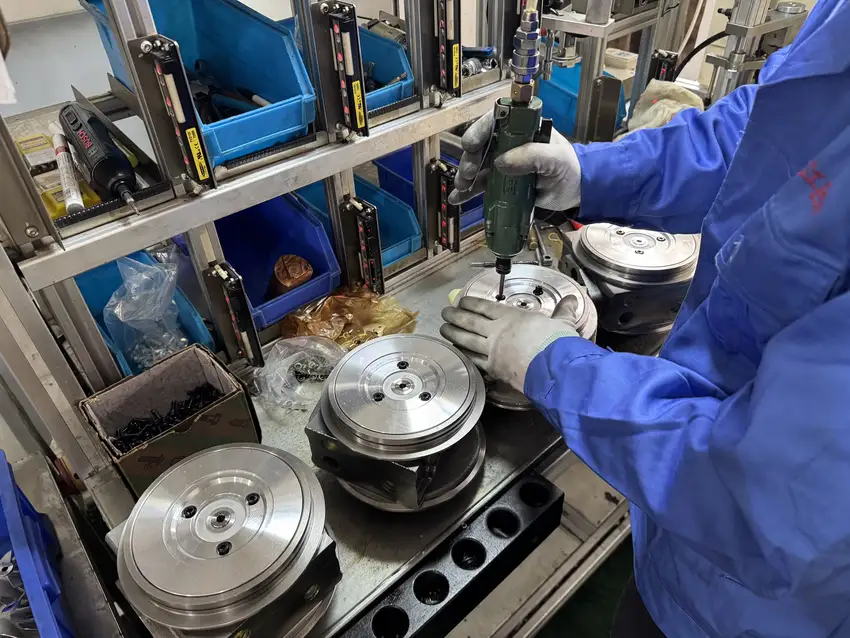 Technician assembling turbo center housings at a real workshop bench