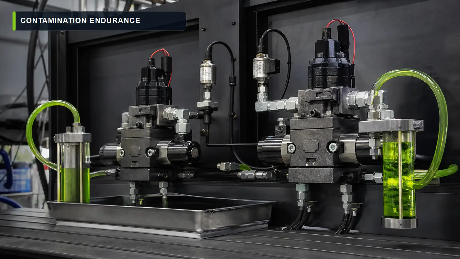 Two heavy-duty solenoid valves on a controlled contamination endurance rig with sight glasses and leak containment
