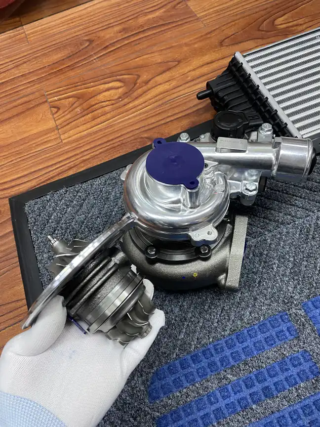 Hand-held turbocharger core assembly beside a complete turbocharger on a work surface